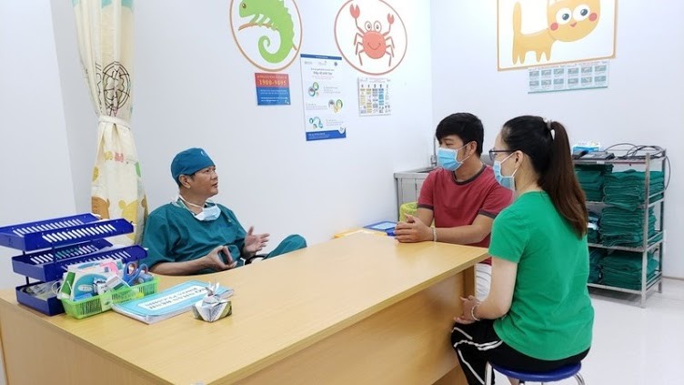 TS-BS Trương Quang Định, Giám đốc Bệnh viện Nhi đồng Thành phố gặp bố mẹ hai cháu bé giải thích diễn tiến, kết quả sơ bộ  cuộc mổ. Ảnh: BVCC