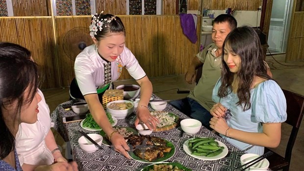 Thiếu nữ Thái mời khách quý món ăn truyền thống Pa Pỉnh Tộp. (Ảnh: Xuân Mai/Vietnam+)