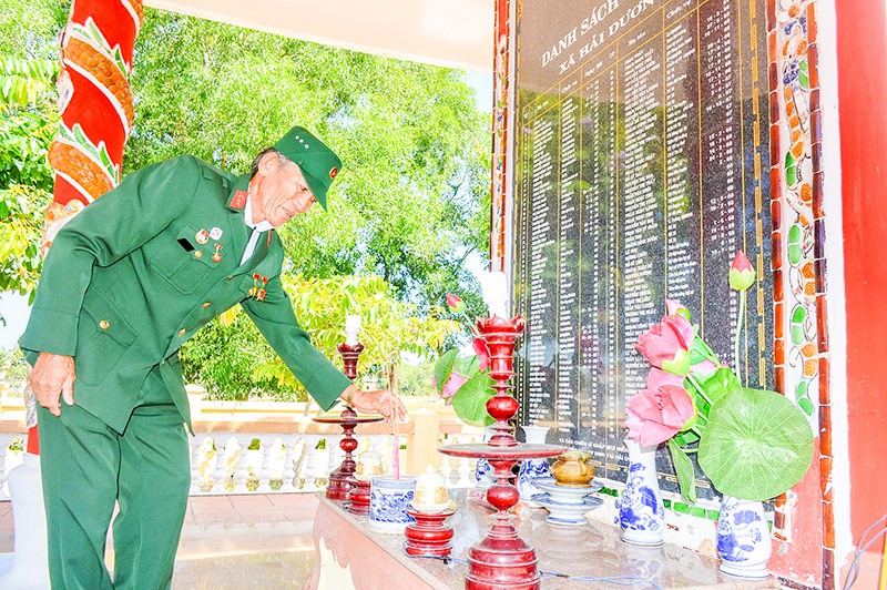 Ông Trần Học tự nguyện chăm sóc Đài tưởng niệm liệt sĩ xã Hải Dương, huyện Hải Lăng. Ảnh: Đ.V
