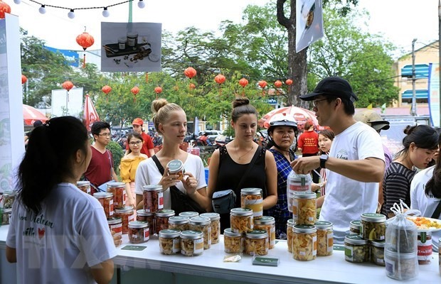 Du khách nước ngoài tham quan mua sắm tại Liên hoan ẩm thực quốc tế tại Festival Huế 2018. (Ảnh: Hoàng Hùng/TTXVN)