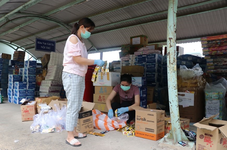 Các điều dưỡng của Trung tâm y tế huyện Hòa Vang có thêm nhiệm vụ phân chia đồ dùng, nhu yếu phẩm. (Ảnh: Quốc Dũng/TTXVN)
