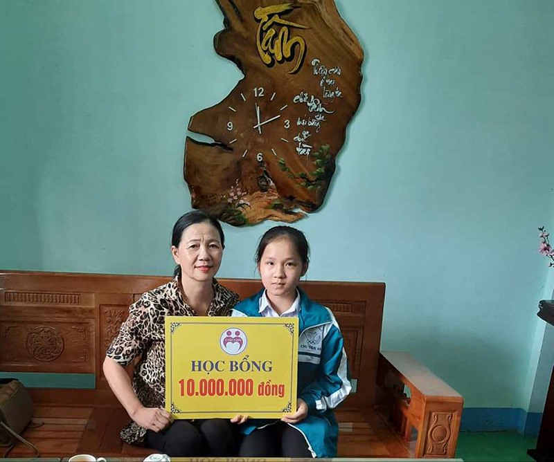 Em Lê Thị Tường Vy, học sinh Trường THPT Chu Văn An, huyện Triệu Phong vui mừng khi nhận được học bổng do cô giáo Thái Thị Lan trao tặng - Ảnh: H.T​