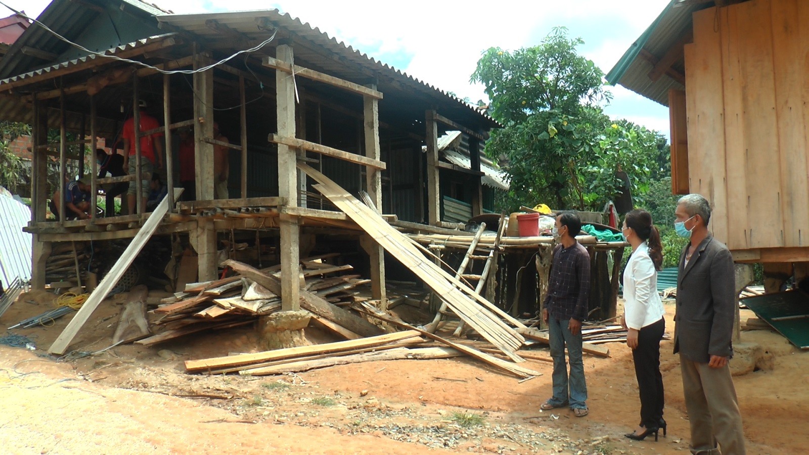Chị Đinh Thị Kiều Oanh, thành viên nhóm Thiện nguyện Khe Sanh và anh Hồ A Dơi bên căn nhà đang được sửa chữa