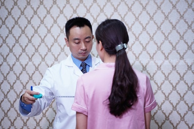 Thạc sỹ Nguyễn Đình Minh kiểm tra các chỉ số cho nữ bệnh nhân. (Ảnh: PV/Vietnam+)