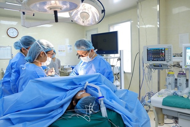 Các bác sỹ thực hiện ca phẫu thuật tạo hình thẩm mỹ cho bệnh nhân. (Ảnh: PV/Vietnam+)