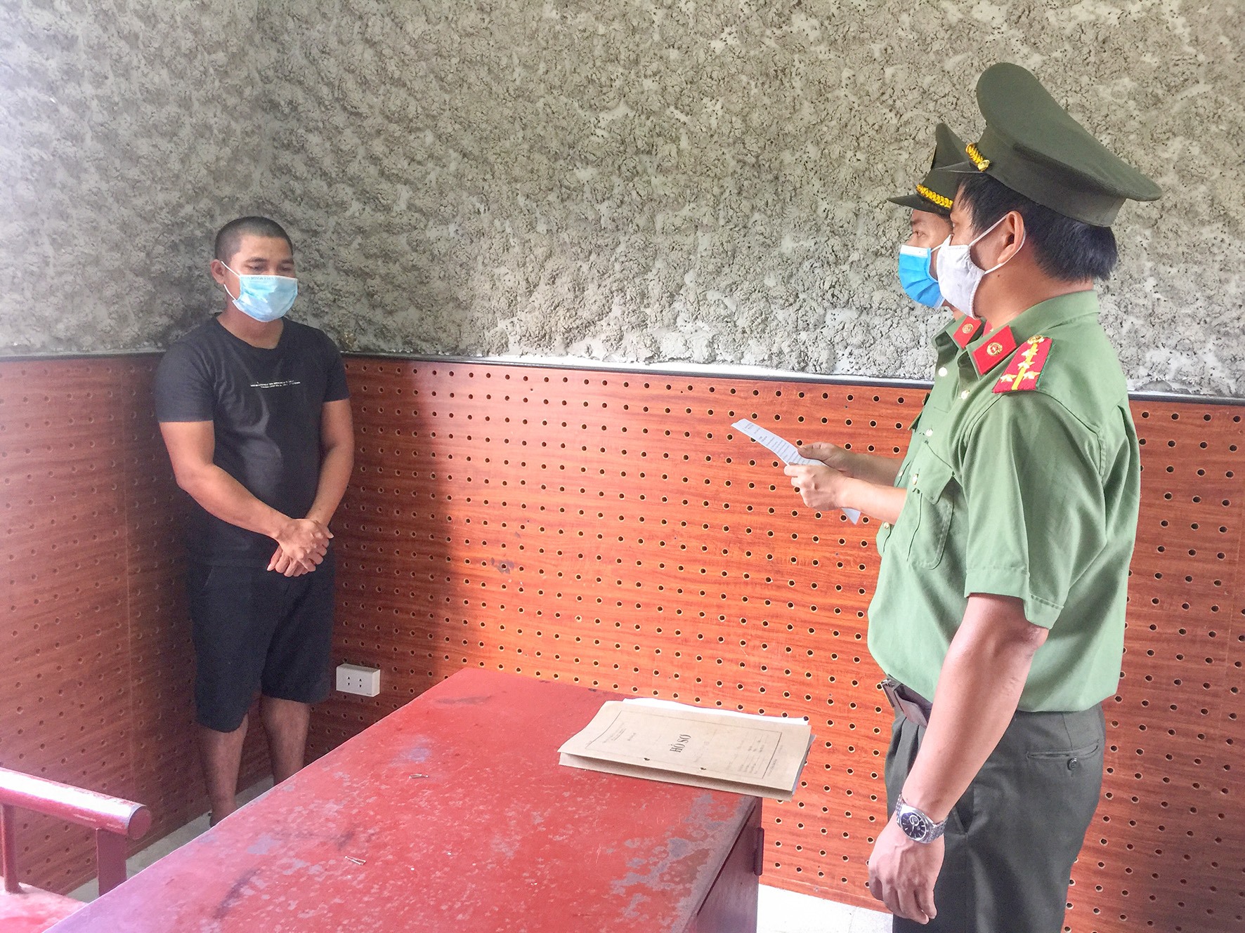 Lực lượng chức năng đọc lệnh bắt tạm giam Hồ Văn Den -Ảnh: T.K