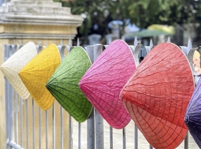 Hoạ sỹ Nguyễn Thanh Thảo tạo ra những chiếc nón lá sen 'xuyên sáng' với 5 sắc màu. (Ảnh: Mai Trang/TTXVN)