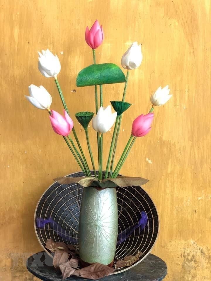 Hoạ sỹ Nguyễn Thanh Thảo tạo ra những chiếc nón lá sen 'xuyên sáng' với 5 sắc màu. (Ảnh: Mai Trang/TTXVN)