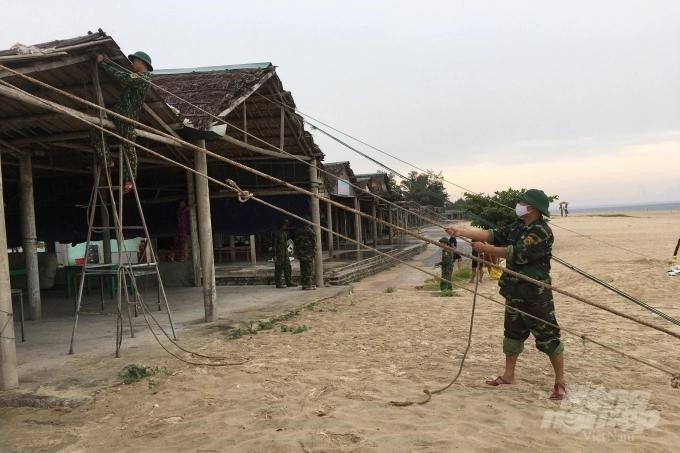 Bộ đội Biên phòng Quảng Trị giúp người dân chằng chống quán xá ở bãi biển Cửa Việt.