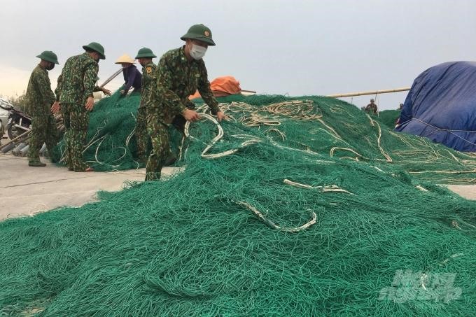Bộ đội Biên phòng Quảng Trị giúp ngư dân thu dọn ngư lưới cụ.