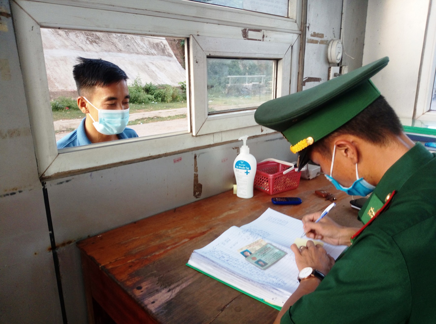 Cán bộ Đồn Biên phòng Cửa khẩu quốc tế Lao Bảo giải quyết thủ tục xuất cảnh cho người dân-Ảnh: H.N​