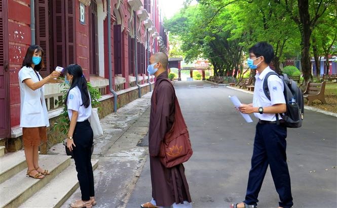 Lực lượng y tế đo thân nhiệt cho các thí sinh trước khi vào phòng thi của tỉnh Thừa Thiên - Huế. Ảnh: Tường Vi /TTXVN
