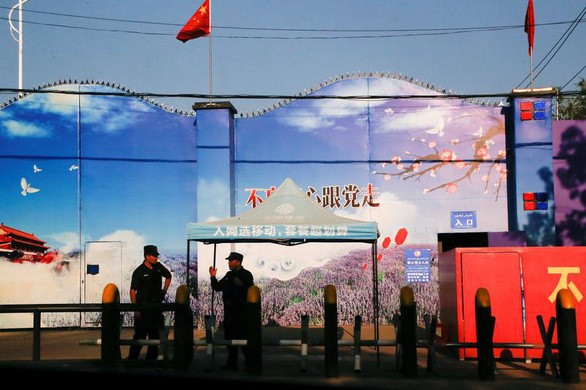 Nhân viên bảo vệ đứng gác ở cổng trung tâm dạy nghề ở khu tự trị Tân Cương, Trung Quốc - Ảnh: REUTERS