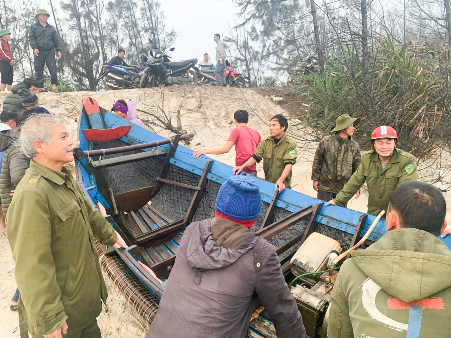 Lực lượng chức năng xã Vĩnh Thái kịp thời đưa thuyền bị nạn vào bờ an toàn-Ảnh: Nguyễn Trang