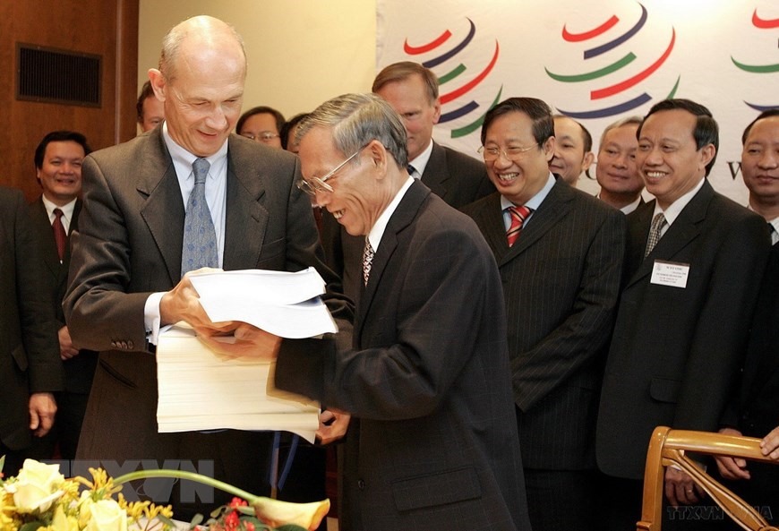 Ngày 7/11/2006, Bộ trưởng Thương mại Trương Đình Tuyển và Tổng giám đốc Tổ chức Thương mại Thế giới (WTO) Pascal Lamy ký Nghị định thư gia nhập WTO của Việt Nam. (Ảnh: AFP/TTXVN)