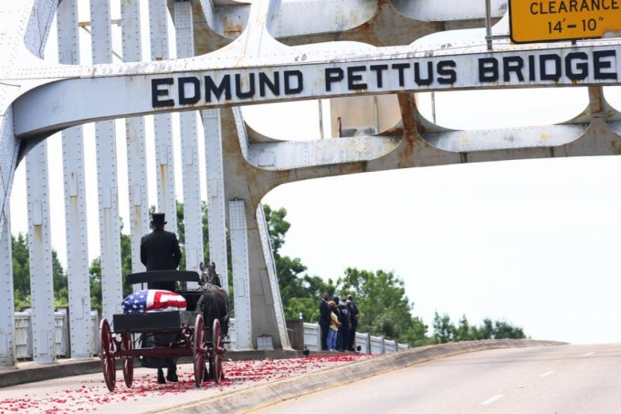 Chiếc xe ngựa chở thi hài của biểu tượng dân quyền John Lewis băng qua cầu Edmund Pettus và đi qua các thành viên trong gia đình ông vào ngày 26/7 ở Selma, Alabama (Mỹ). Ảnh: Getty Images