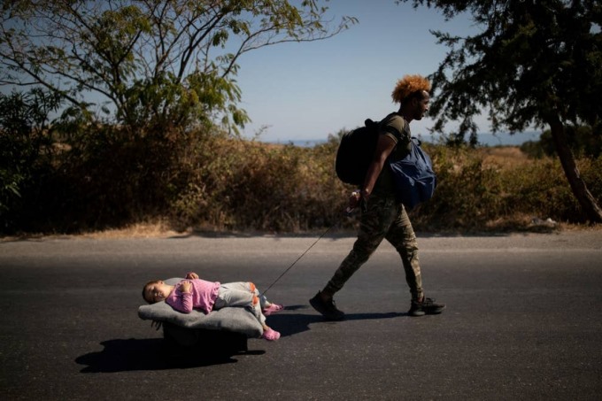 Một người di cư kéo bé gái nằm trên xe đẩy sau đám cháy tại trại tị nạn Moria trên đảo Lesbos, Hy Lạp ngày 9/9. Ảnh: Reuters