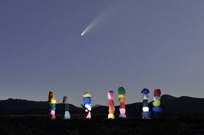 Sao chổi Neowise bay trên bầu trời, phía dưới là tác phẩm sắp đặt nghệ thuật “Bảy ngọn núi kỳ diệu” ở Jean, bang Nevada (Mỹ) ngày 15/7. Ảnh: Getty Images.