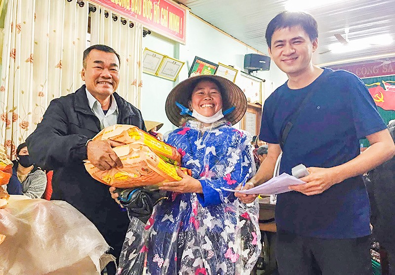 Trưởng thôn Nguyễn Như Khoa (ngoài cùng, bên phải) trong một lần phát quà cho người dân-Ảnh: TÚ LINH​