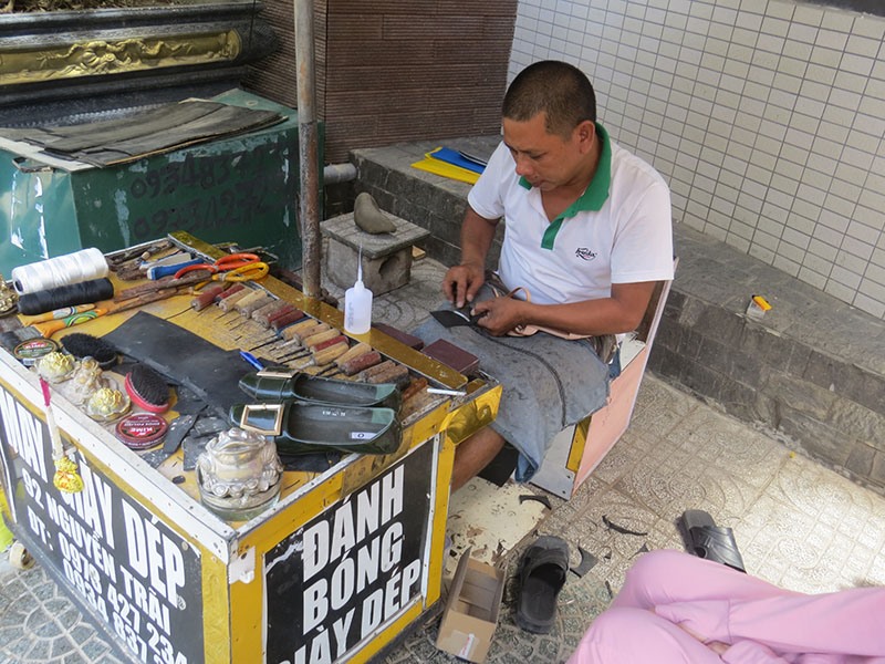 Anh Nguyễn Hoàng hơn 30 năm mưu sinh ở vỉa hè bằng nghề sửa giày -Ảnh: KHÁNH LINH