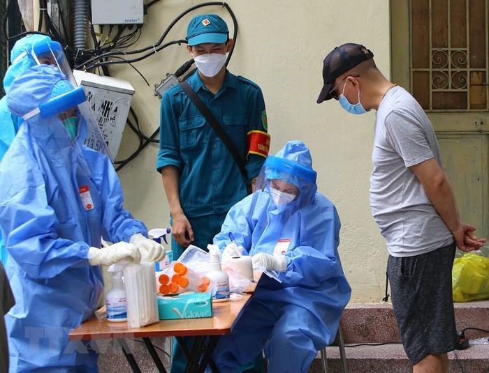 Người dân phường Hàng Bông khai báo y tế trước khi lấy mẫu xét nghiệm, sáng 3/10. (Ảnh: Hải Anh/TTXVN)