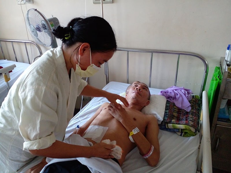 Chị Trần Thị Mùi chăm sóc chồng tại Bệnh viện Trung ương Huế - Ảnh: NVCC