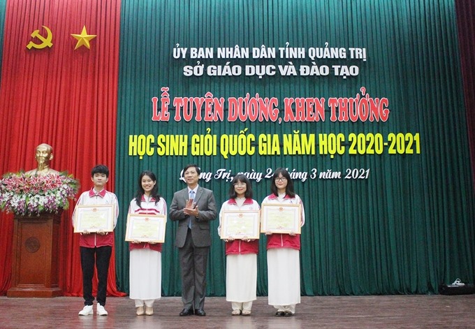 Phó Chủ tịch UBND tỉnh Quảng Trị Hoàng Nam trao Bằng khen của Chủ tịch UBND tỉnh cho các học sinh đoạt giải Nhì HSGQG. (Ảnh: Tú Linh)