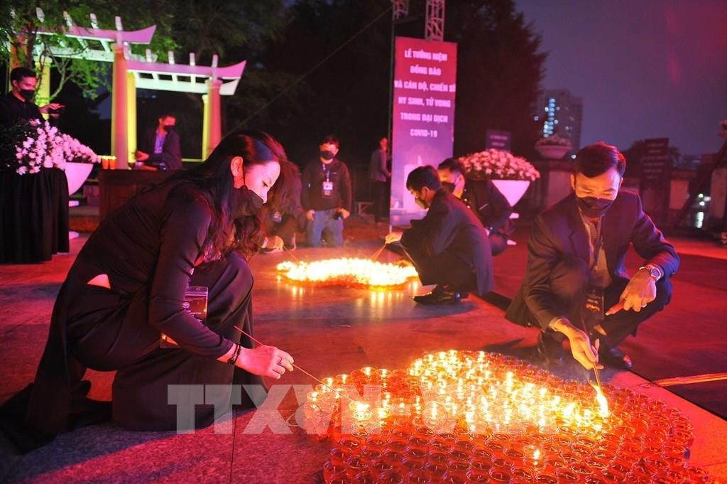 Tại Công viên Thống Nhất (Hà Nội), các đại biểu và nhân dân thắp nến tưởng niệm đồng bào và cán bộ, chiến sĩ hy sinh, tử vong trong đại dịch COVID-19.