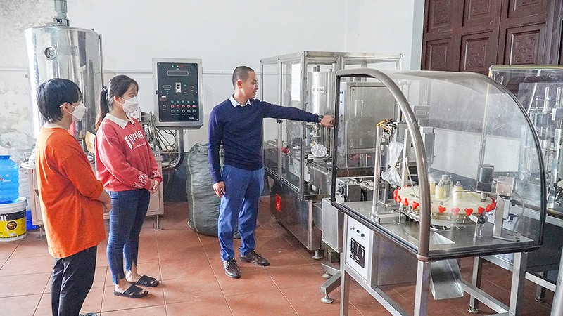 Anh Lê Thanh Huệ đang hướng dẫn cho công nhân sử dụng thiết bị chiết xuất tinh dầu-Ảnh: A.V