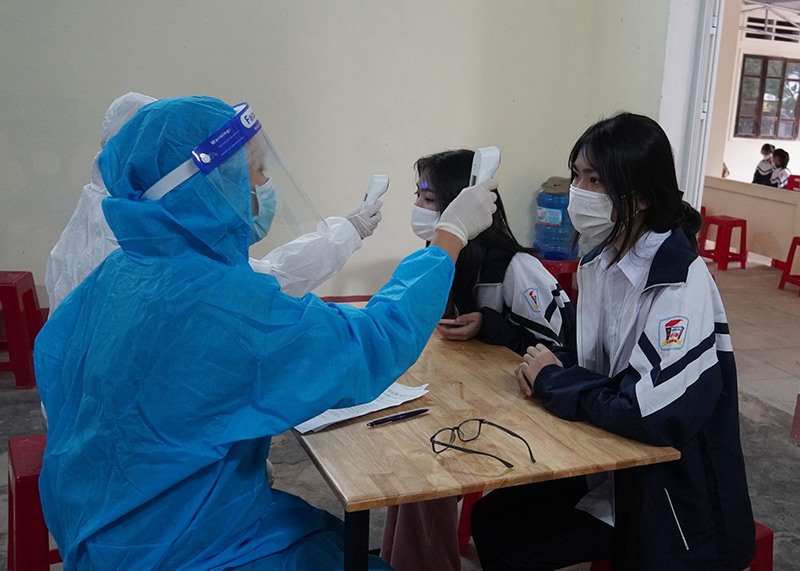 Nhân viên y tế kiểm tra sức khỏe của học sinh trước khi tiêm vắc xin phòng COVID-19 -Ảnh: H.N