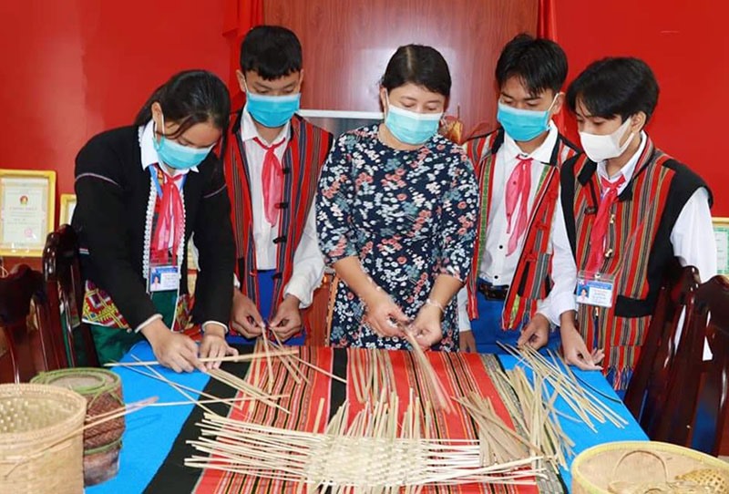 Giáo viên Trường Phổ thông Dân tộc nội trú huyện Hướng Hóa hướng dẫn cho học sinh cách đan lát vật dụng truyền thống - Ảnh: N.T