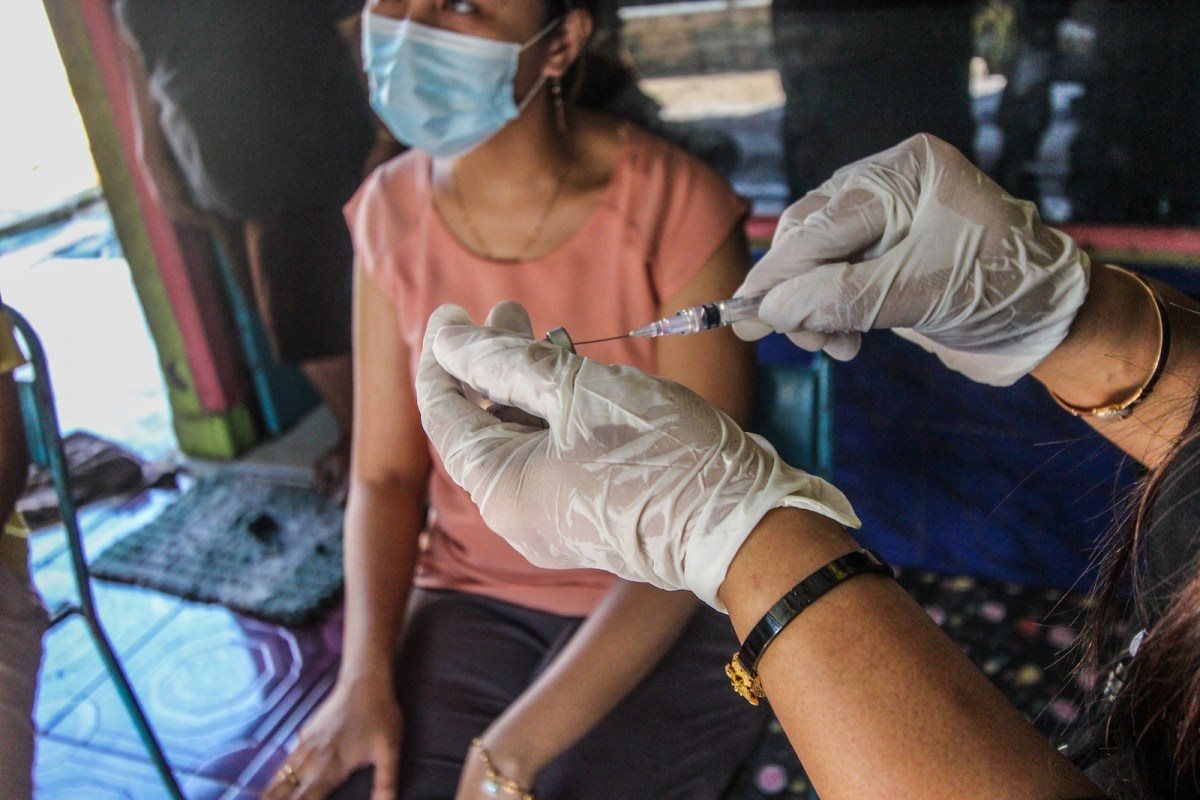 Một người dân Indonesia được tiêm vaccine.