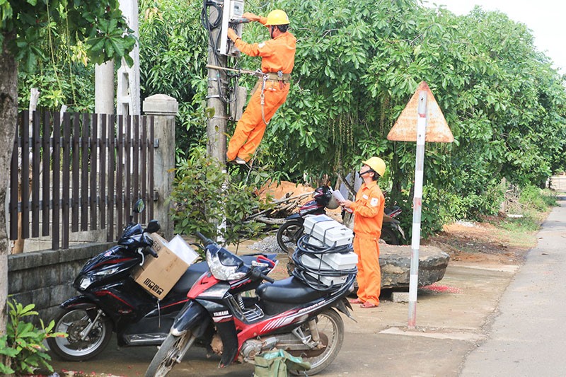 Công nhân Điện lực Vĩnh Linh thay mới công tơ điện cho khách hàng - Ảnh: H.N.K