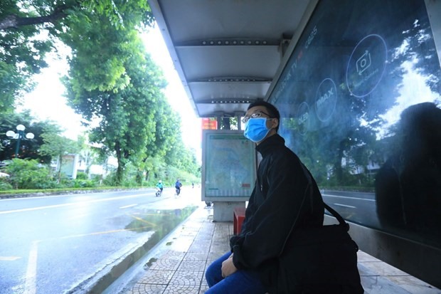 Người dân chờ xe buýt tại trạm đón, trả khách trên phố Giảng Võ, Hà Nội. (Ảnh: Tuấn Anh/TTXVN)