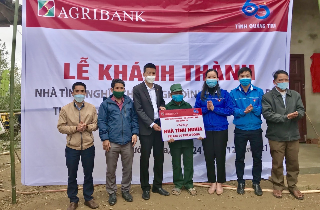 Đại diện Agribank Quảng Trị trao tiền hỗ trợ xây dựng nhà tình nghĩa cho gia đình ông Hồ Văn Du - Ảnh: CTV