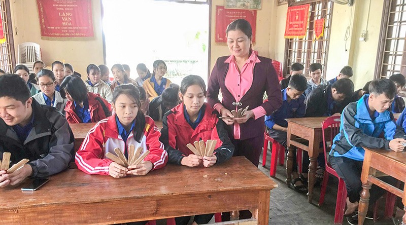 Bà Hồ Thị Linh đang truyền dạy cách chơi bài chòi cho thanh thiếu niên làng Ngô Xá Tây -Ảnh: THANH HẰNG