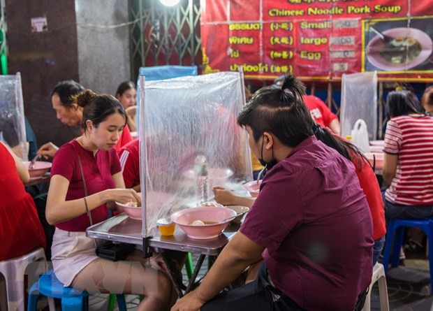 Một quán ăn ở Bangkok sử dụng tấm chắn để ngăn dịch bệnh lây lan. (Ảnh: AFP/TTXVN)