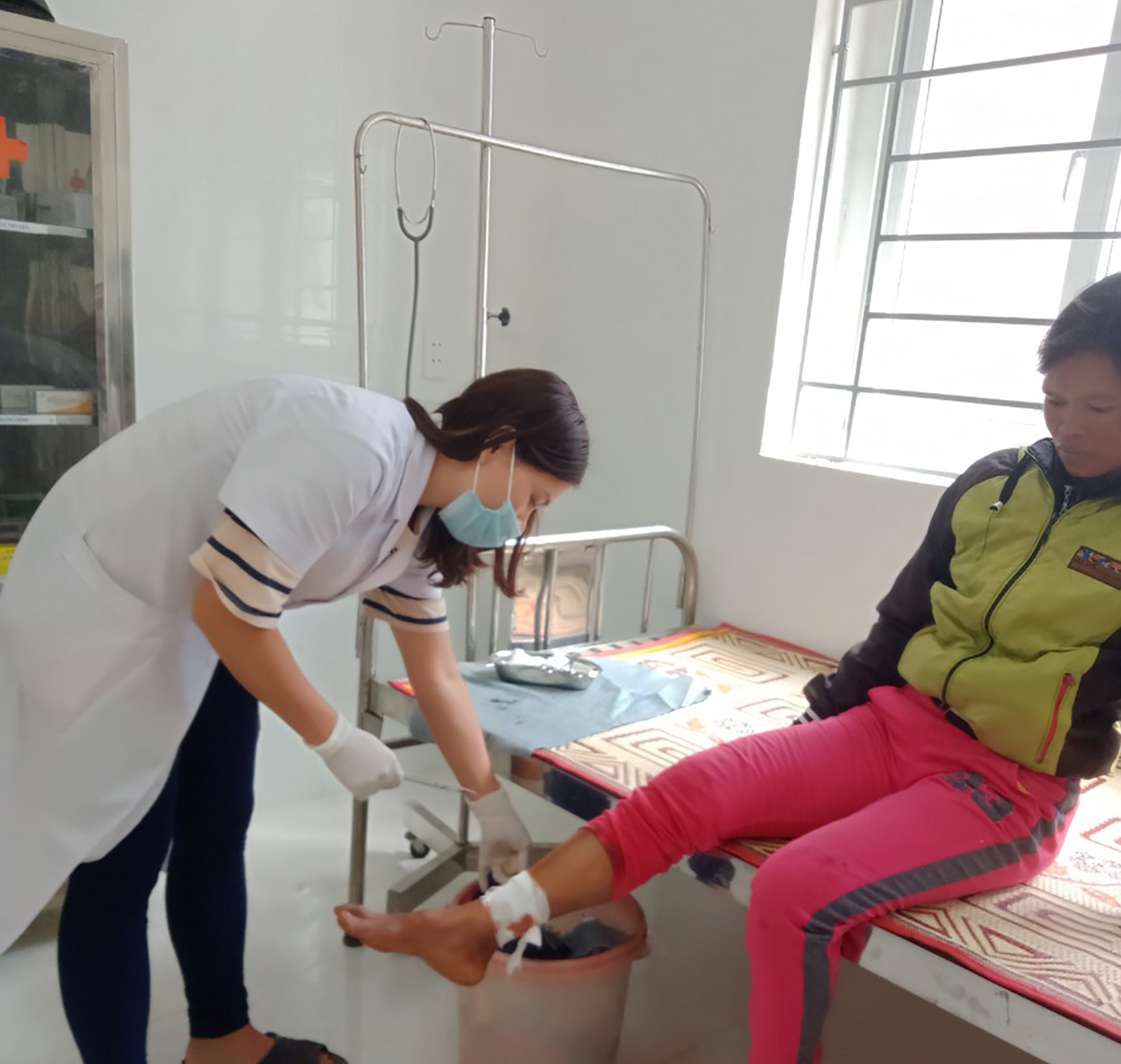 Chị Hồ Thị Ở được nhân viên y tế khâu vết thương-Ảnh: Hoàng Táo