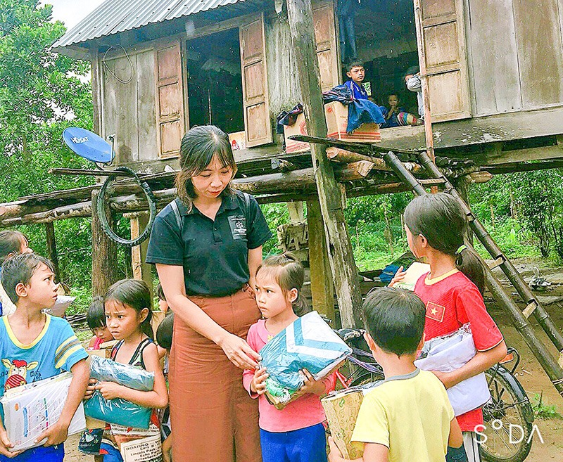 Chị Phan Thị Chung trao quần áo ấm cho trẻ em nghèo vùng cao -Ảnh: LÂM PHƯƠNG​