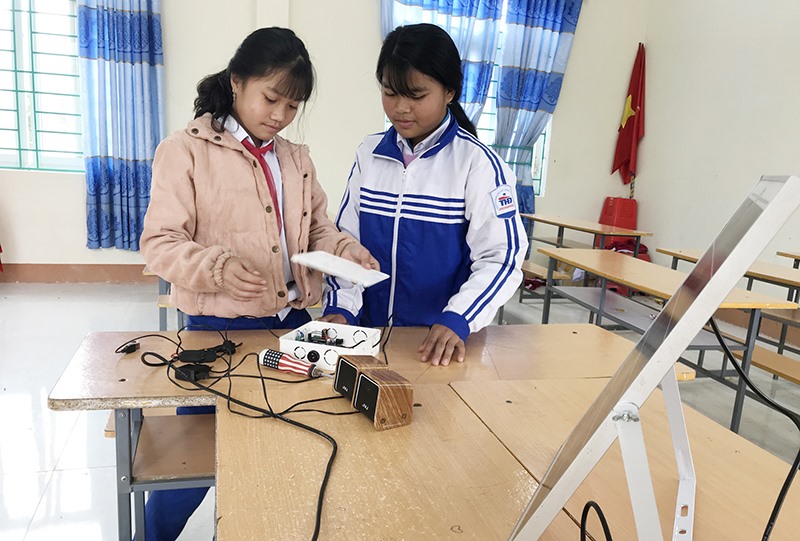 Em Hồ Thị Hà My (bên trái) và Hồ Thị Chuyên lắp ráp và thử nghiệm máy “Nhắc nhở thông minh” - Ảnh: TÚ LINH​