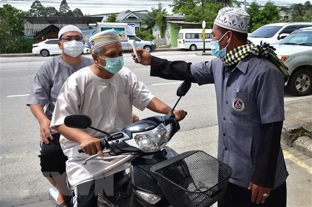 Kiểm tra thân nhiệt nhằm ngăn chặn sự lây lan của dịch COVID-19 trước khi vào một đền thờ Hồi giáo ở Narathiwat, Thái Lan. (Ảnh: AFP/TTXVN)
