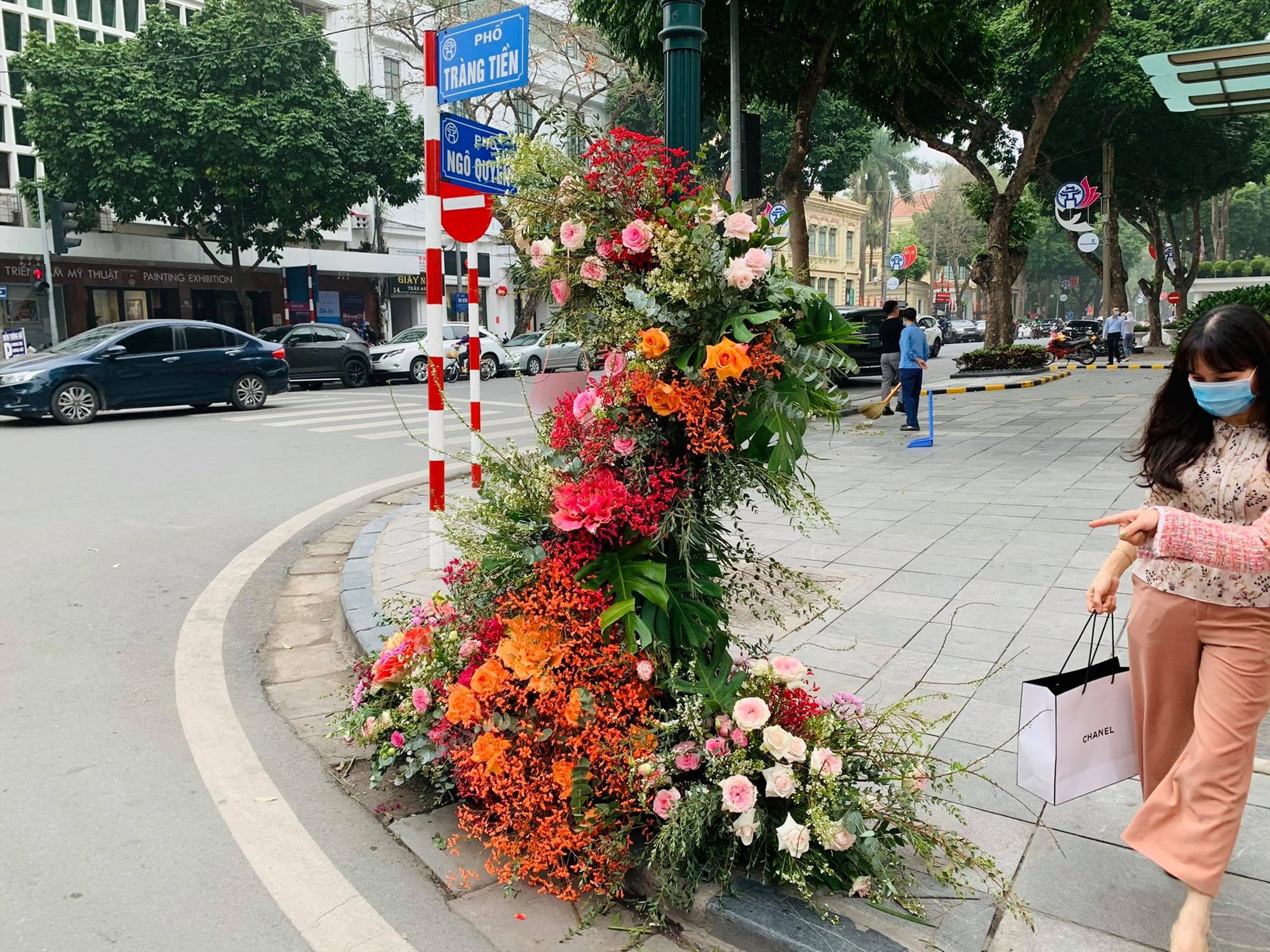 Một cột đèn ngay gần khách sạn Metropole được trang trí những chùm hoa tươi rực rỡ thu hút người dân.