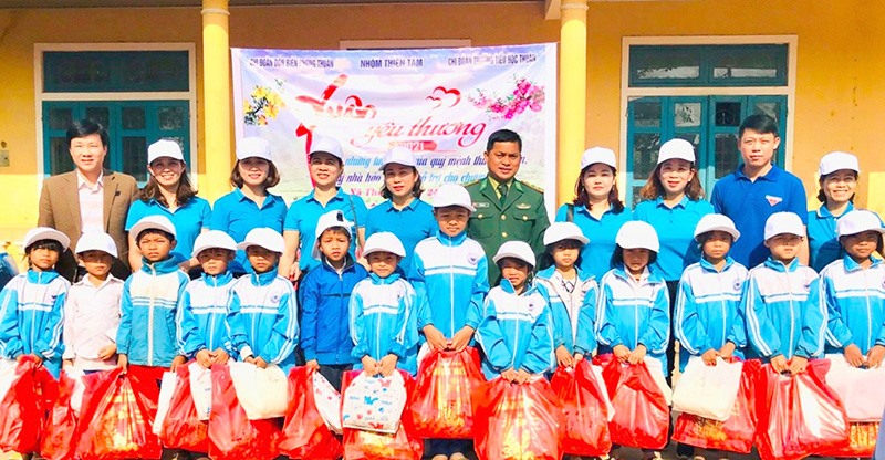 Chị Thương (hàng sau, thứ hai, từ trái sang) cùng các tổ chức, cá nhân hảo tâm tổ chức chương trình “Xuân yêu thương” cho các em học sinh Trường Tiểu học Thuận - Ảnh: M.L​