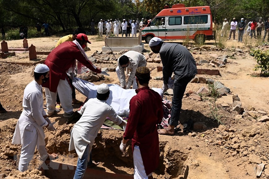 Chôn cất thi thể bệnh nhân COVID-19 tại một nghĩa trang ở New Delhi, Ấn Độ, ngày 3/4/2021. (Ảnh: AFP/TTXVN)