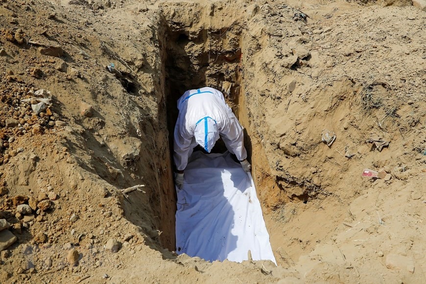 Chuẩn bị chôn cất thi thể bệnh nhân COVID-19 tại một nghĩa trang ở New Delhi, Ấn Độ ngày 23/4/2021. (Ảnh: Reuters/TTXVN)