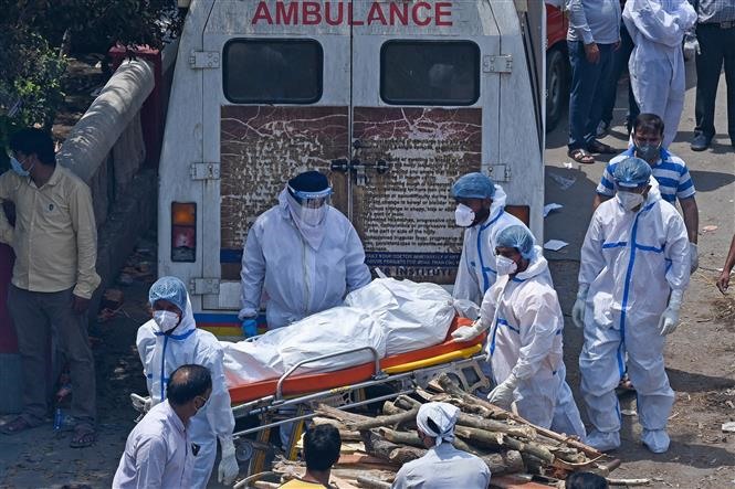 Nhân viên y tế chuyển thi thể bệnh nhân COVID-19 tới khu hỏa táng ở New Delhi, Ấn Độ ngày 27/4/2021. Ảnh: AFP/TTXVN