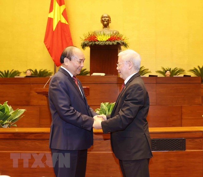 Chủ tịch nước Nguyễn Xuân Phúc tặng hoa đồng chí Nguyễn Phú Trọng, nguyên Chủ tịch nước. (Ảnh: Trí Dũng/TTXVN)