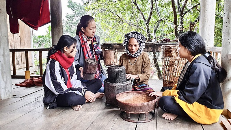 Học sinh Trường Phổ thông Dân tộc nội trú Vĩnh Linh tìm hiểu nghề đan lát truyền thống của các nghệ nhân tại xã Vĩnh Ô - Ảnh: N.T​