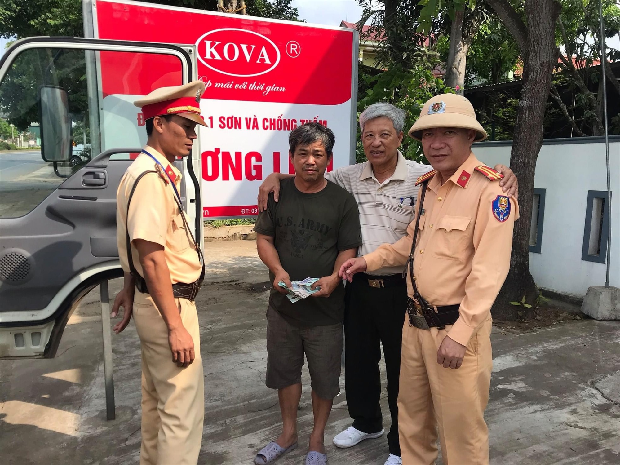 Đội Cảnh sát giao thông Công an huyện Vĩnh Linh trả lại tiền cho người bị mất - Ảnh: NVCC