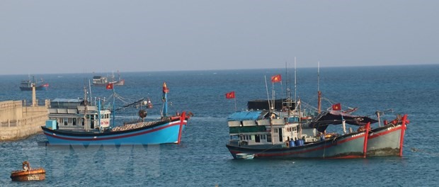 Cờ Tổ quốc tung bay phấp phới trên nóc tàu đánh cá của ngư dân Việt Nam neo đậu tại đảo Đá Tây A (quần đảo Trường Sa). (Ảnh: Sỹ Tuyên/TTXVN)
